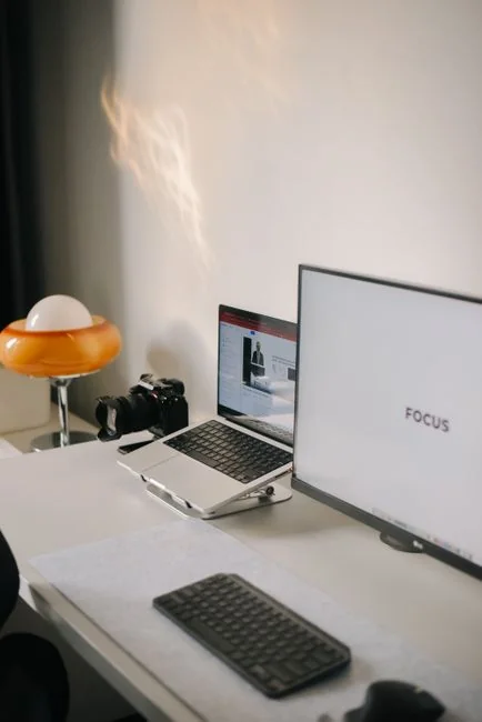 Gros plan sur des mains en train d’interagir avec un site de shopping sur l’écran d’un ordinateur portable, en intérieur.